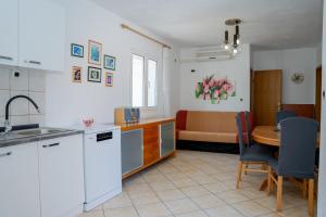 a kitchen and living room with a table and a couch at Villa Best Relax in Okrug Donji