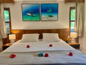 a bedroom with a bed with red flowers on it at Pousada do Vale in Fernando de Noronha +50 photos