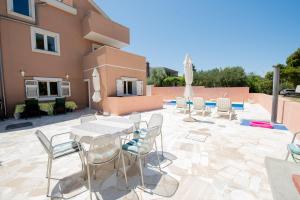 a patio with tables and chairs and a building at Villa Best Relax in Okrug Donji