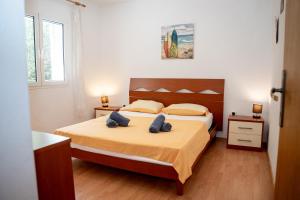 a bedroom with a bed with two blue pillows at Villa Best Relax in Okrug Donji +37 photos