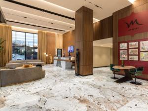 a lobby of a hotel with a large marble floor at Mercure Tirana in Tirana