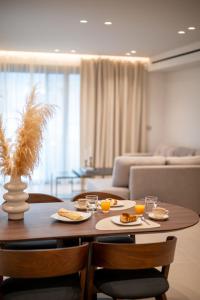 a table with two plates of food on it in a living room at ΛΑΚΩΝΙΖΕΙΝ Luxury Suites in Sparta