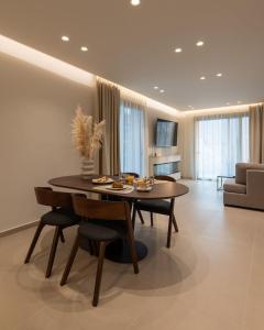 a dining room table and chairs in a living room at ΛΑΚΩΝΙΖΕΙΝ Luxury Suites in Sparta
