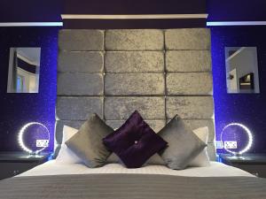 a bedroom with a large bed with purple pillows at The 25 Boutique B&B - Adults Only in Torquay