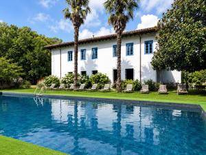 a house with a swimming pool in front of a building at Hotel Termas de Liérganes in Liérganes