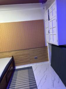 a small room with a bed and a wooden wall at LALEAH Transient House in Cotabato