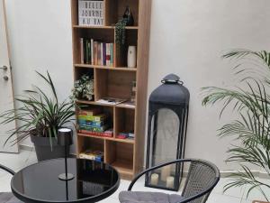 a table and chairs in a room with a book shelf at Au bât Tournai chambre Bohème in Tournai