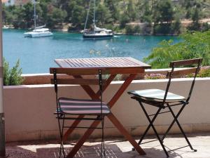 a wooden table and two chairs with a view of the water at Perla Vacation Home in Sutivan