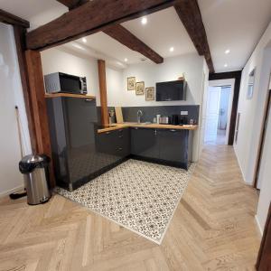 a kitchen with a sink and a microwave in a room at Le FENUA in Colmar