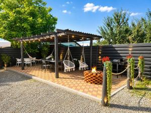 a patio with a fire pit and a pergola at New Venus in Curtea de Argeş