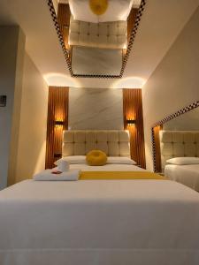 a bedroom with a large white bed with yellow pillows at URBAN suites in Lima