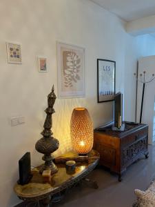a living room with a table with a lamp and a tv at Mar de rosas in Carcavelos