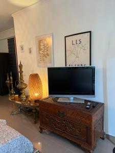 a living room with a flat screen tv on a dresser at Mar de rosas in Carcavelos