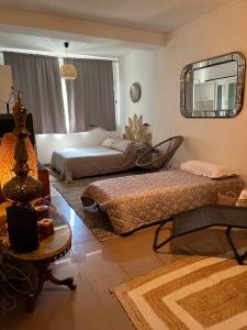 a living room with two beds and a mirror at Mar de rosas in Carcavelos +11 photos