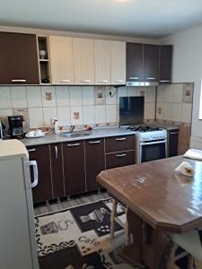 a kitchen with wooden cabinets and a wooden table at Căsuța galbenă in Bucharest +42 photos