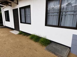 a white house with a door and some plants at Sterappel Sun Stay in Paramaribo