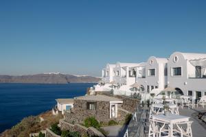 a view of a building with the ocean in the background at The Duchess in Therasia