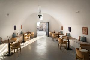 a restaurant with tables and chairs in a room at The Duchess in Therasia