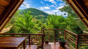 a balcony with a table and a view of trees at Glenora Wood Cabin in Ella