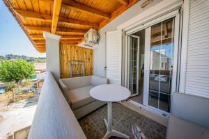 a balcony with a couch and a table at Casa Damour in Sidari