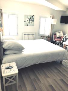 a large bed in a bedroom with a table at Hôtel Le Galet Bleu in Fouras