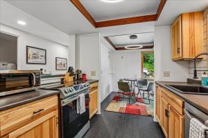 a kitchen with wooden cabinets and a table with chairs at The Mercer House in Stowe