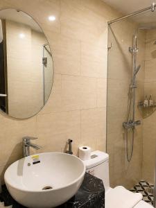 a bathroom with a white sink and a shower at Hanoi Silk Crown Boutique Hotel & Spa in Hanoi