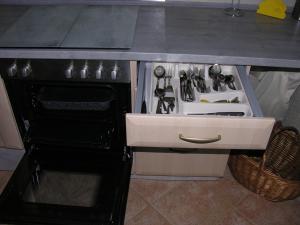 a kitchen counter with a sink and an open oven at Ferienwohnung Auenweg in Radebeul