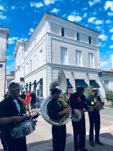 a group of men playing instruments on a street at Hôtel Le Galet Bleu in Fouras +4 photos