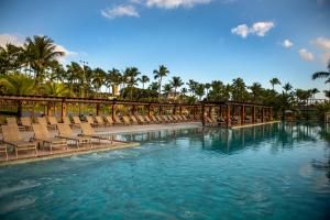 a large swimming pool with chairs and water at Cana Brava All Inclusive Resort in Ilhéus
