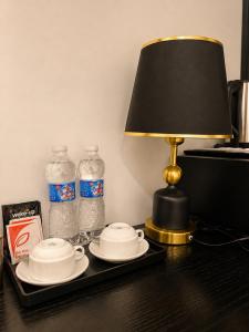 a table with a lamp and two bottles of water at Hanoi Silk Crown Boutique Hotel & Spa in Hanoi +16 photos