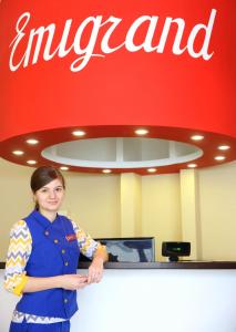 a woman standing in front of a counter in an airport at Emigrand Art Hotel in Uzhhorod