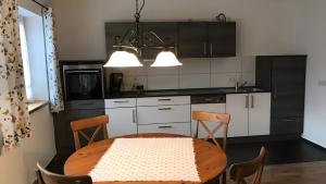 a kitchen with a table and chairs and a kitchen with black cabinets at Unter der Linde in Tittmoning