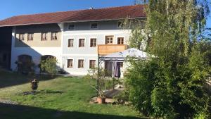 a large white house with a tree in the yard at Unter der Linde in Tittmoning