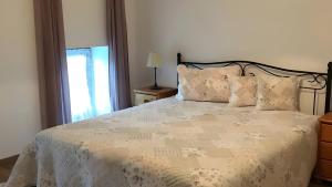 a bedroom with a white bed with pillows and a window at Unter der Linde in Tittmoning