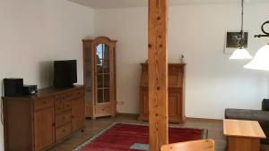 a living room with a tv on a wooden dresser at Unter der Linde in Tittmoning
