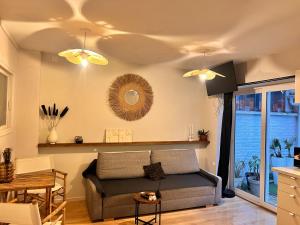 a living room with a couch and a table at les thermes du beffroi in Calais