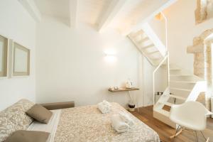 a white bedroom with a bed and a staircase at Iulius Suite in Conversano