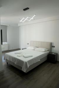 a bedroom with a large white bed with a light at Ceylan Apart Otel in Tekirdağ