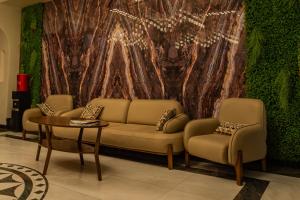 a living room with a couch and chairs and a wall at Hanzade Palace in Samarkand