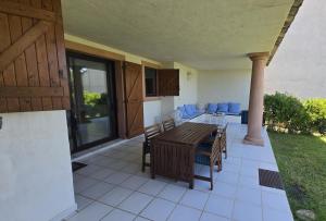 a patio with a table and chairs on a house at Favone Mini Villa Playa del Oro in Favone