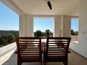 two wooden chairs sitting on a porch with a view at BnB Paradiso in Carloforte