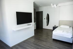 a white room with a bed and a flat screen tv at Ceylan Apart Otel in Tekirdağ