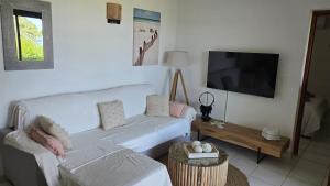 a living room with a couch and a flat screen tv at Favone Mini Villa Playa del Oro in Favone