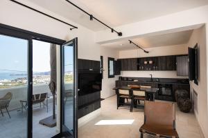 a kitchen and dining room with a view of the ocean at Avento Luxury Suites in Santorini