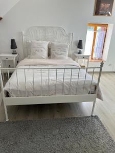a white bed with white sheets and pillows in a bedroom at Chez Karen in Montlay-en-Auxois