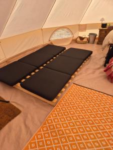 a tent with mats on the floor in a room at Lyng Farm Campsite in Brisley
