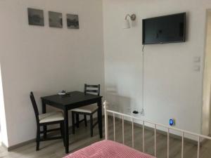 a dining room with a table and a television on the wall at Chez Karen in Montlay-en-Auxois