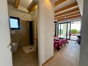 a room with a bed and a bathroom with a shower at BnB Paradiso in Carloforte