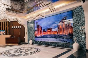 a lobby with a large painting on the wall at Hanzade Palace in Samarkand